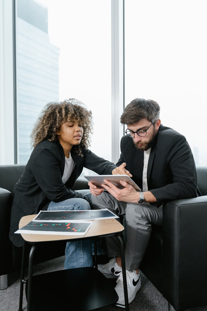 man and woman sitting on black sofa discussing